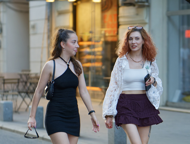 26 - Two sexy women strolling together down a city sidewalk
